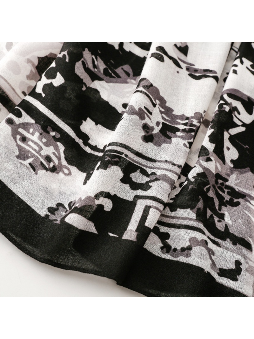 Close-up of the scarf’s broad black border beside floral and abstract motifs