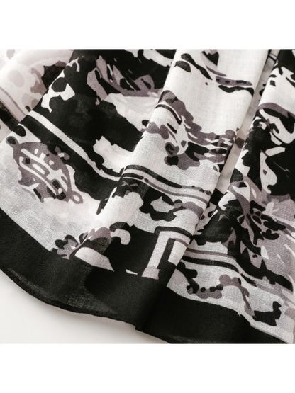 Close-up of the scarf’s broad black border beside floral and abstract motifs