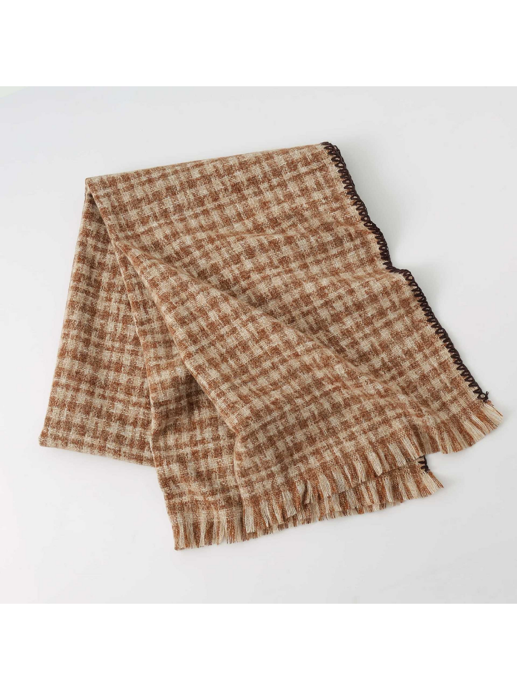 Brown plaid scarf folded on a light background, showing stitched edging and fringe