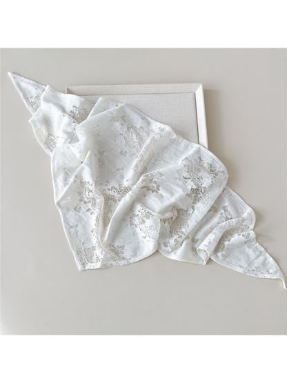 White scarf loosely spread to show floral lace panels and narrow finished edges