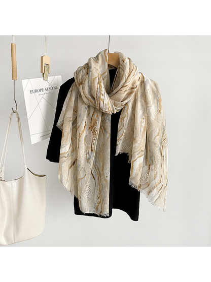 Beige marbled scarf looped around a black top with both ends hanging