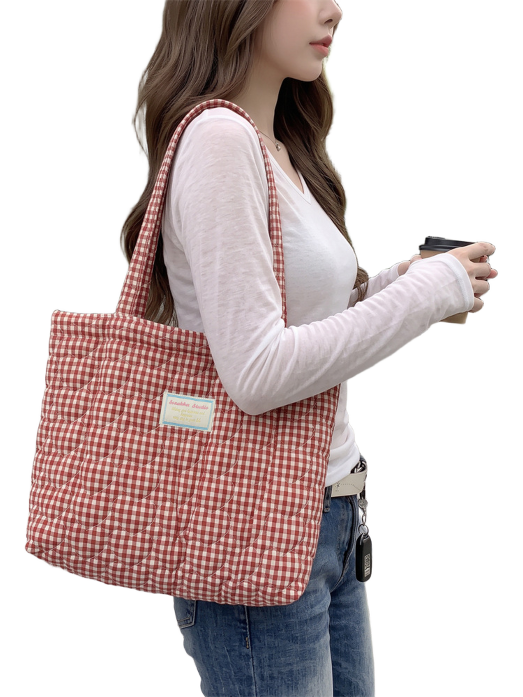 Gingham quilted tote bag worn over a shoulder, close side view