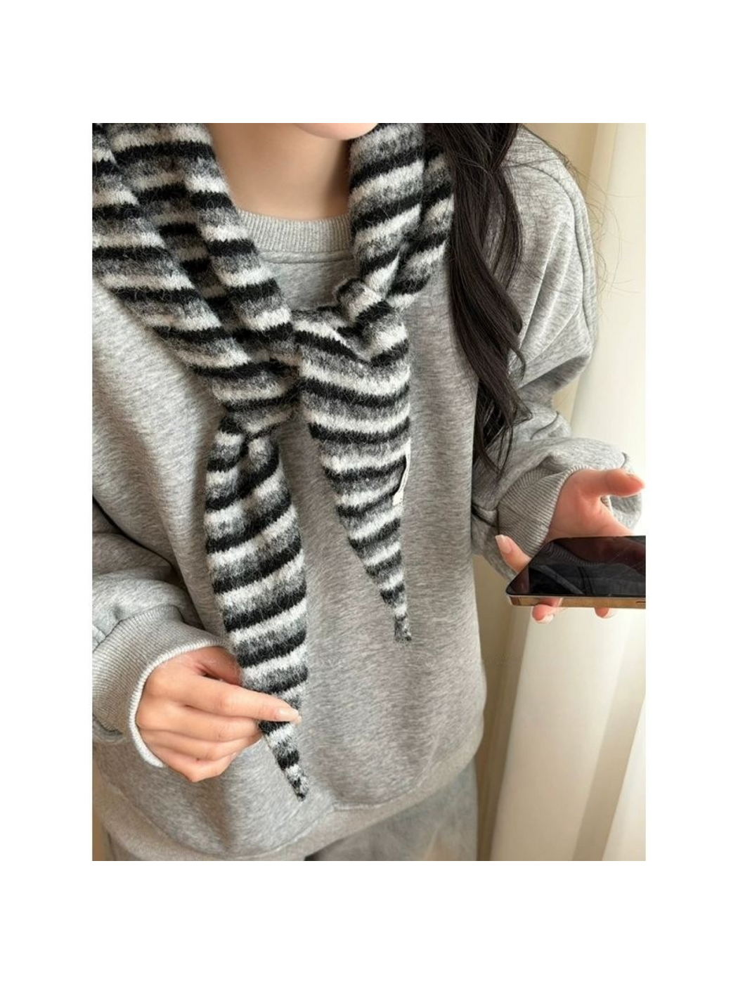 Striped scarf tied at the neck over a gray sweatshirt