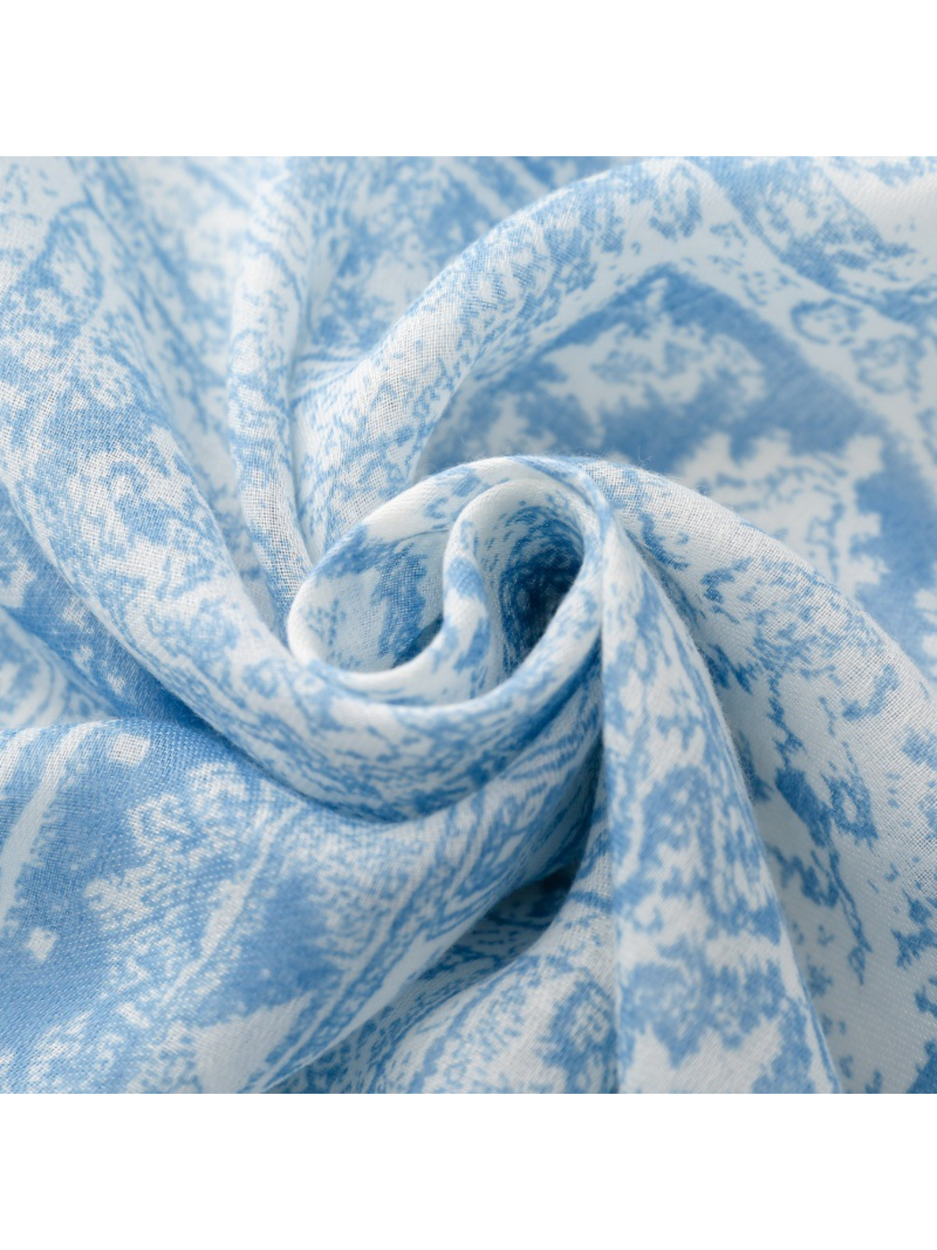 Close-up of blue and white ornamental scarf fabric gathered into curved folds