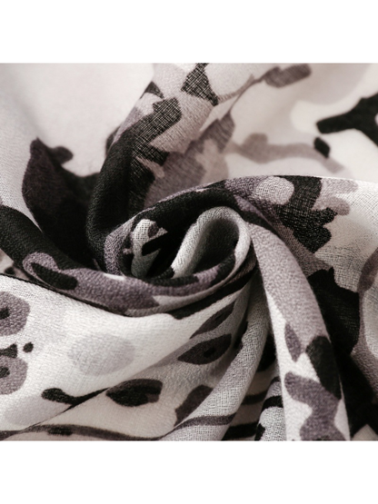 Close-up of the black, gray and white floral scarf gathered into a spiral