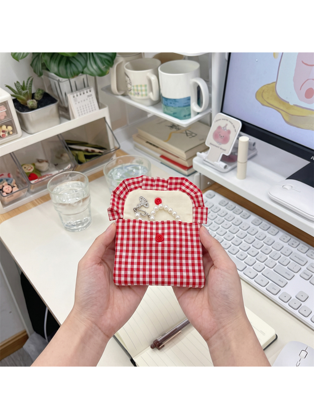 Red gingham coin purse held open, showing the light interior and both snap components