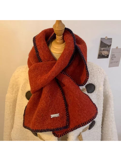 Red scarf looped around a mannequin with dark blanket-stitched edges