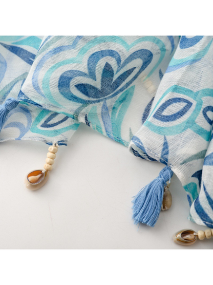 Close-up of the Blue scarf's stitched edge, blue tassels, cream-colored beads and shell-shaped ornaments