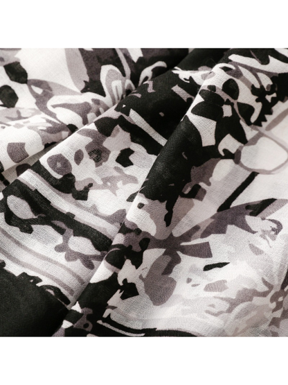 Close-up of floral and abstract motifs across black, gray and white scarf folds