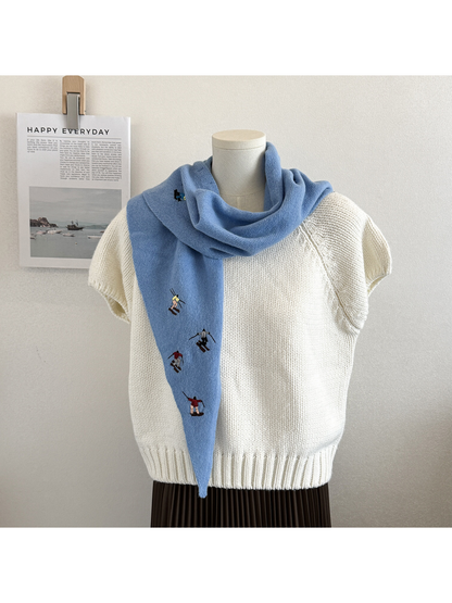 Sky Blue embroidered knit scarf wrapped around the neck with one end hanging in front