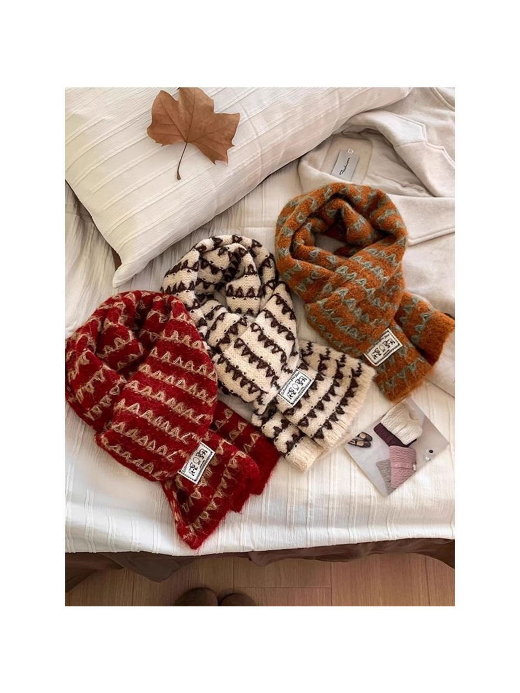 Burgundy, Ivory and Orange patterned knit scarves arranged together on bedding