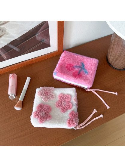 Cherries makeup bag above a Flowers makeup bag, with both pink cord pulls visible