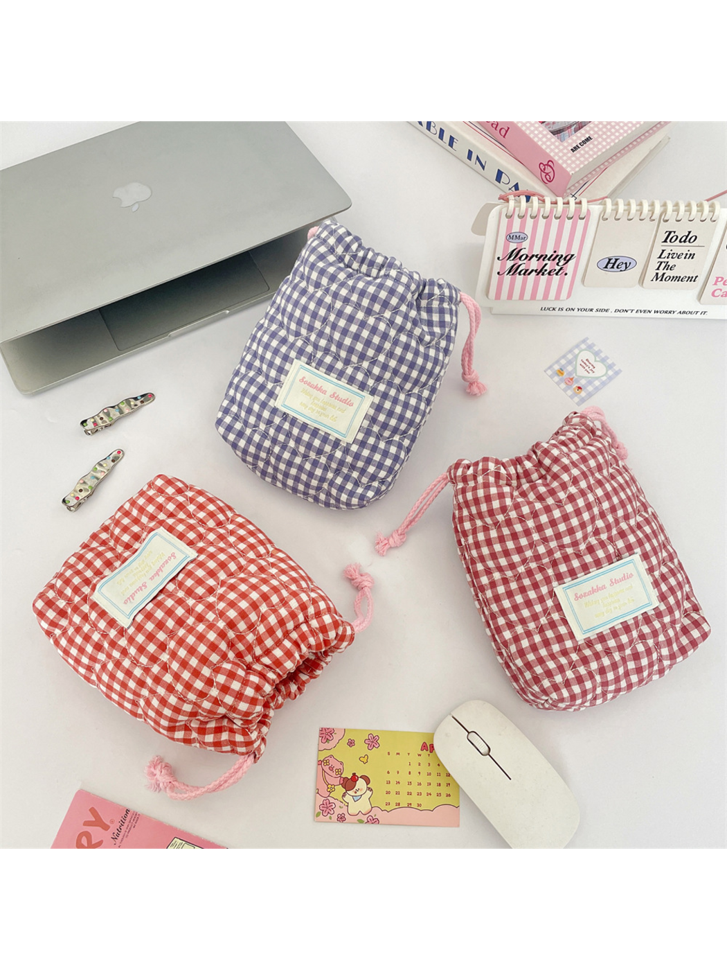 Purple, Red and Pink gingham drawstring pouches arranged at different angles, showing gathered tops and rounded bases
