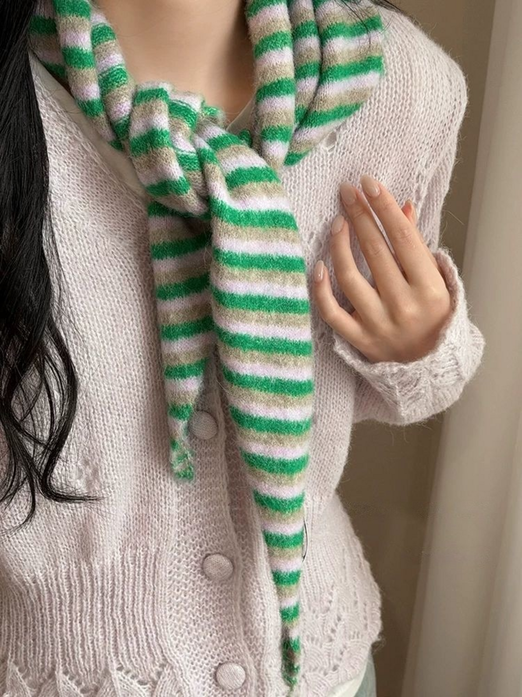 Striped scarf tied at the neck over a pale cardigan