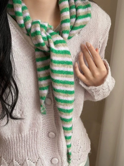 Striped scarf tied at the neck over a pale cardigan