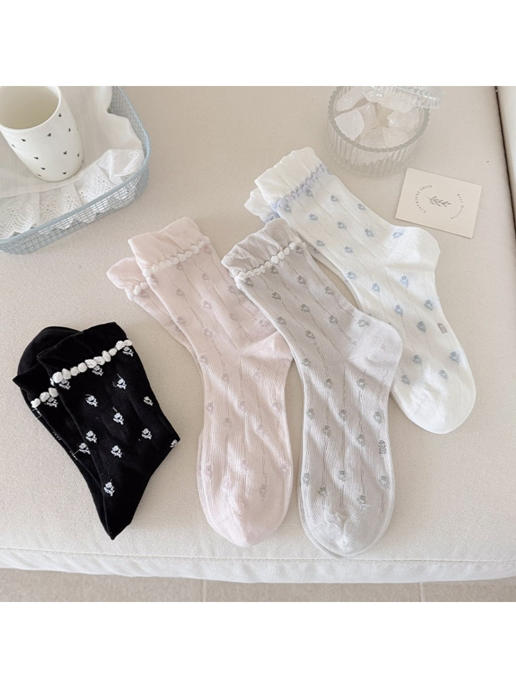 Rufia floral pom trim crew socks folded showing floral pattern and pom pom details