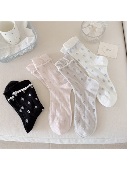 Rufia floral pom trim crew socks folded showing floral pattern and pom pom details