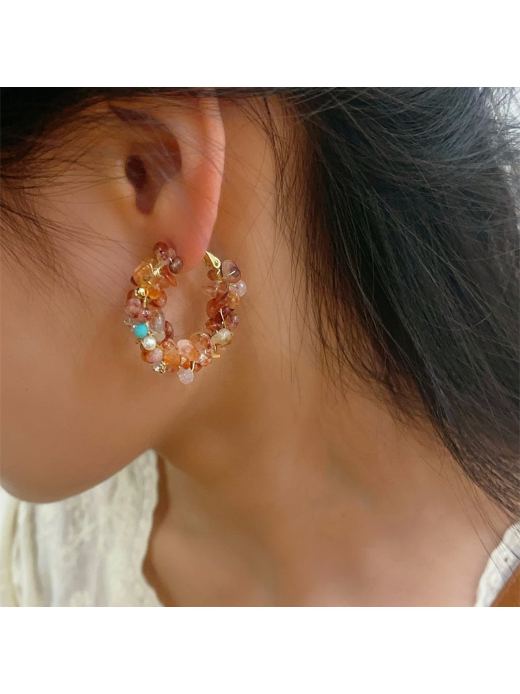 Earwish floral hoop earrings worn on a model's ear