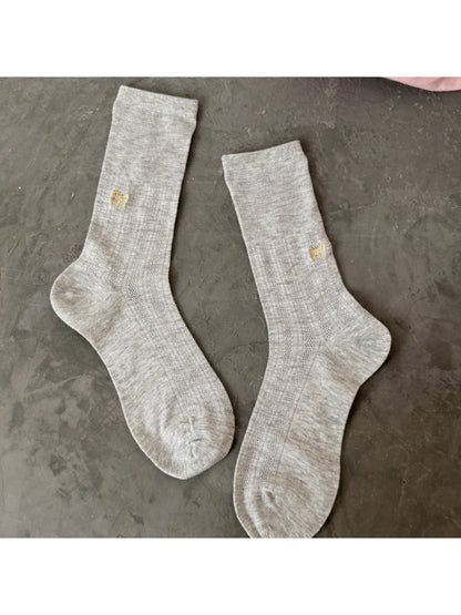 Side view of Rufia slouch sock featuring black cat embroidery