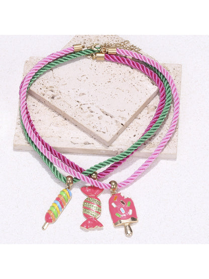 Neckit color rope necklace with candy charms arranged in a circular shape on a plain surface