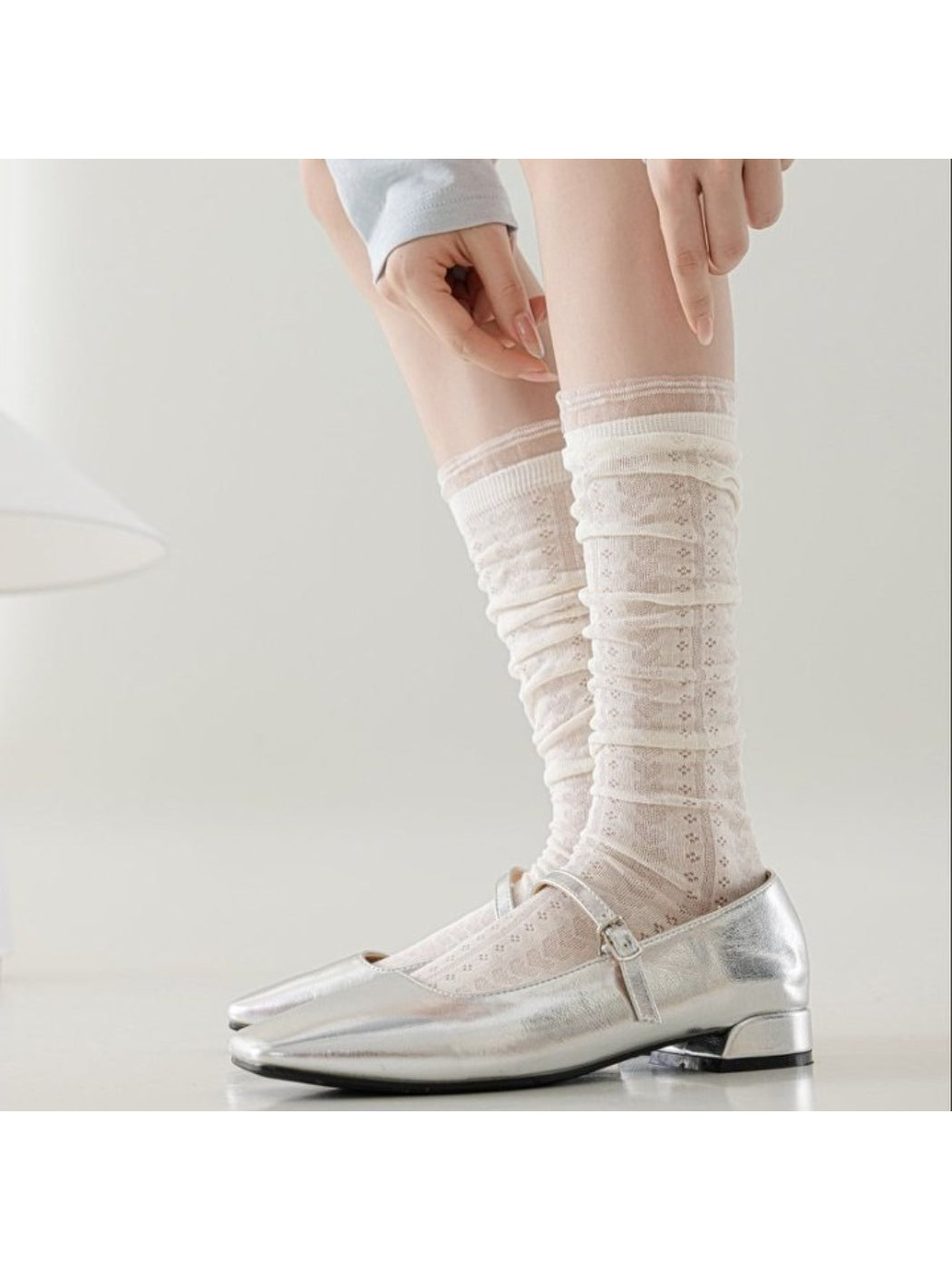Pair of Rufia soft cable knit knee high socks in cream color displayed flat