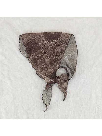 Side view of model with soft paisley triangle head scarf tied at back