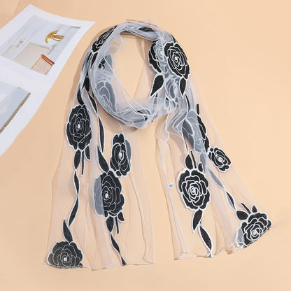 Close-up of delicate rose pattern on sheer mesh scarf fabric