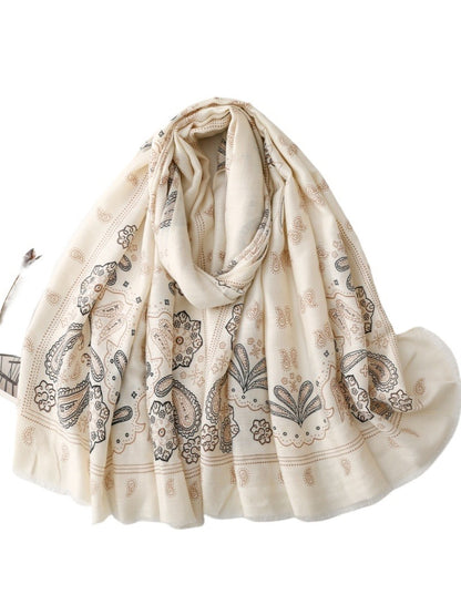 Soft boho paisley scarf casually draped over a chair in natural light