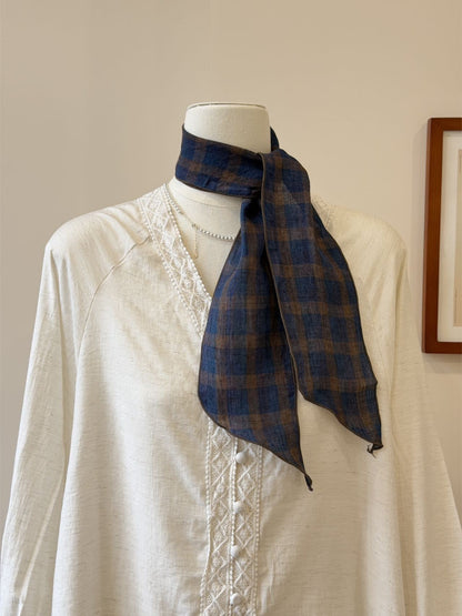 Slim skinny scarf wrapped around neck highlighting its length and slim design