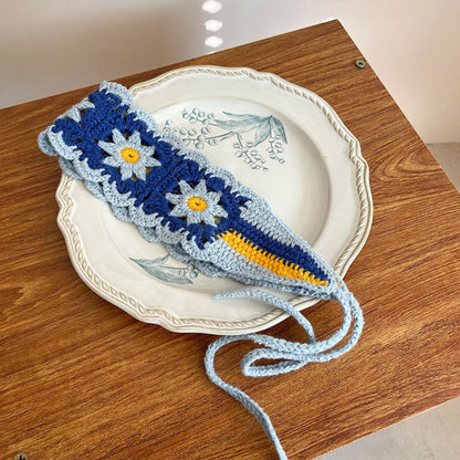 Flat lay of crochet flower hairband with summer-themed props