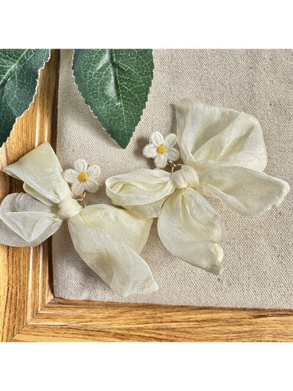 Close-up of Earwish soft ribbon daisy earrings with white petals and yellow centers