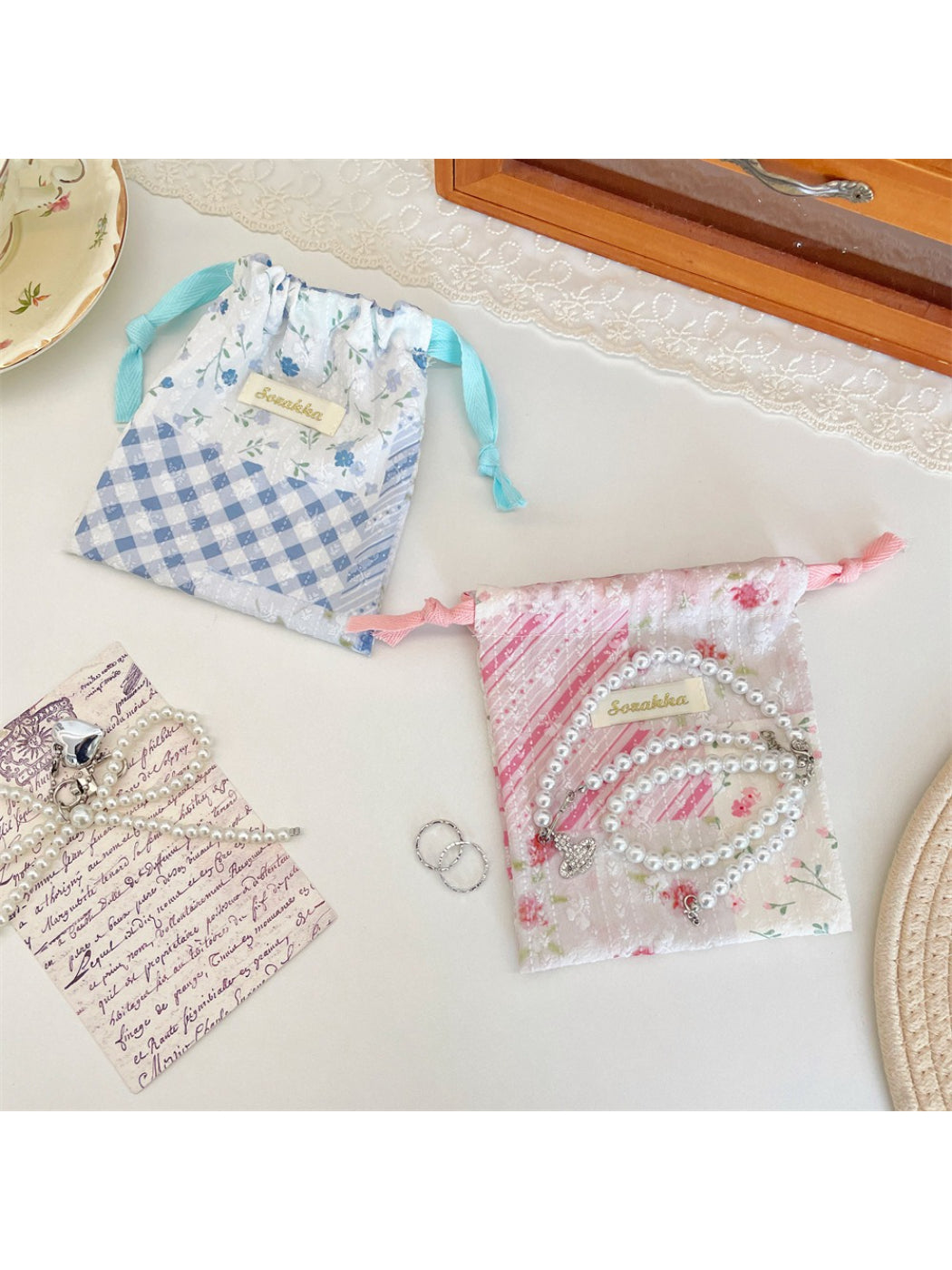 Cosbai floral patchwork pouch held in hand to show size and drawstring feature