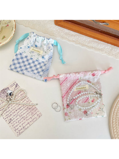 Cosbai floral patchwork pouch held in hand to show size and drawstring feature