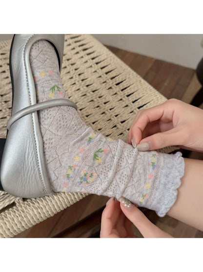 Close-up of Rufia floral lace ankle socks in white on a plain background