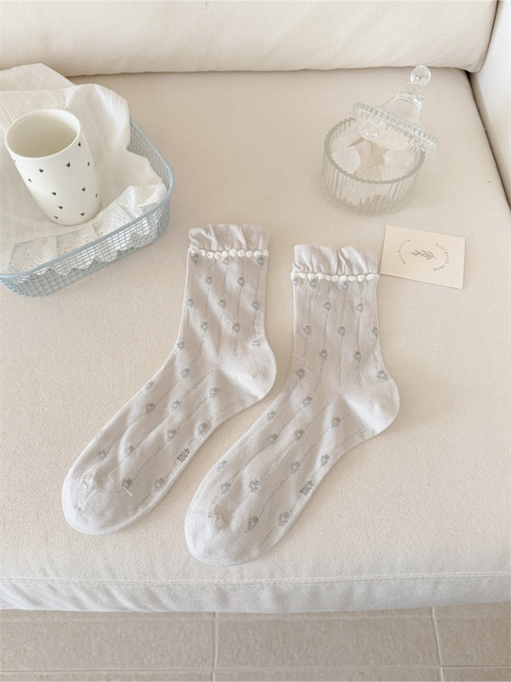 Rufia crew socks styled with a skirt, emphasizing the frilled cuff and floral print