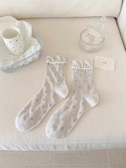 Rufia crew socks styled with a skirt, emphasizing the frilled cuff and floral print