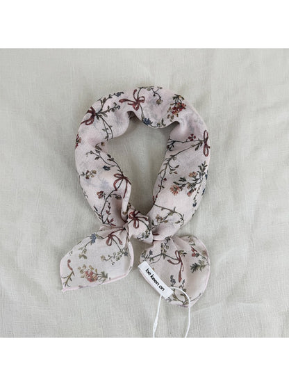 Close-up of Scarvii vintage floral scarf fabric with detailed pink and green floral design