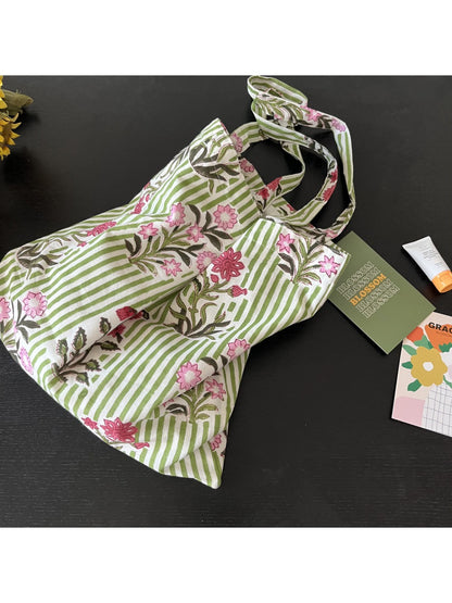 Side view of the Cosbai floral stripe tote bag showing the shoulder strap and charm
