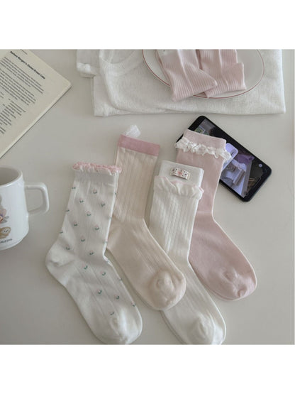Pair of Rufia Dreamy Pastel Bloom crew socks with floral pastel pattern on white background