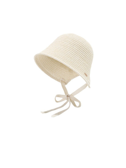 Haila woven straw bucket hat with ribbon tie shown from above on a flat surface