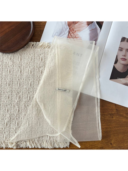 Close-up of scarf fabric showing delicate, translucent texture and fine weave