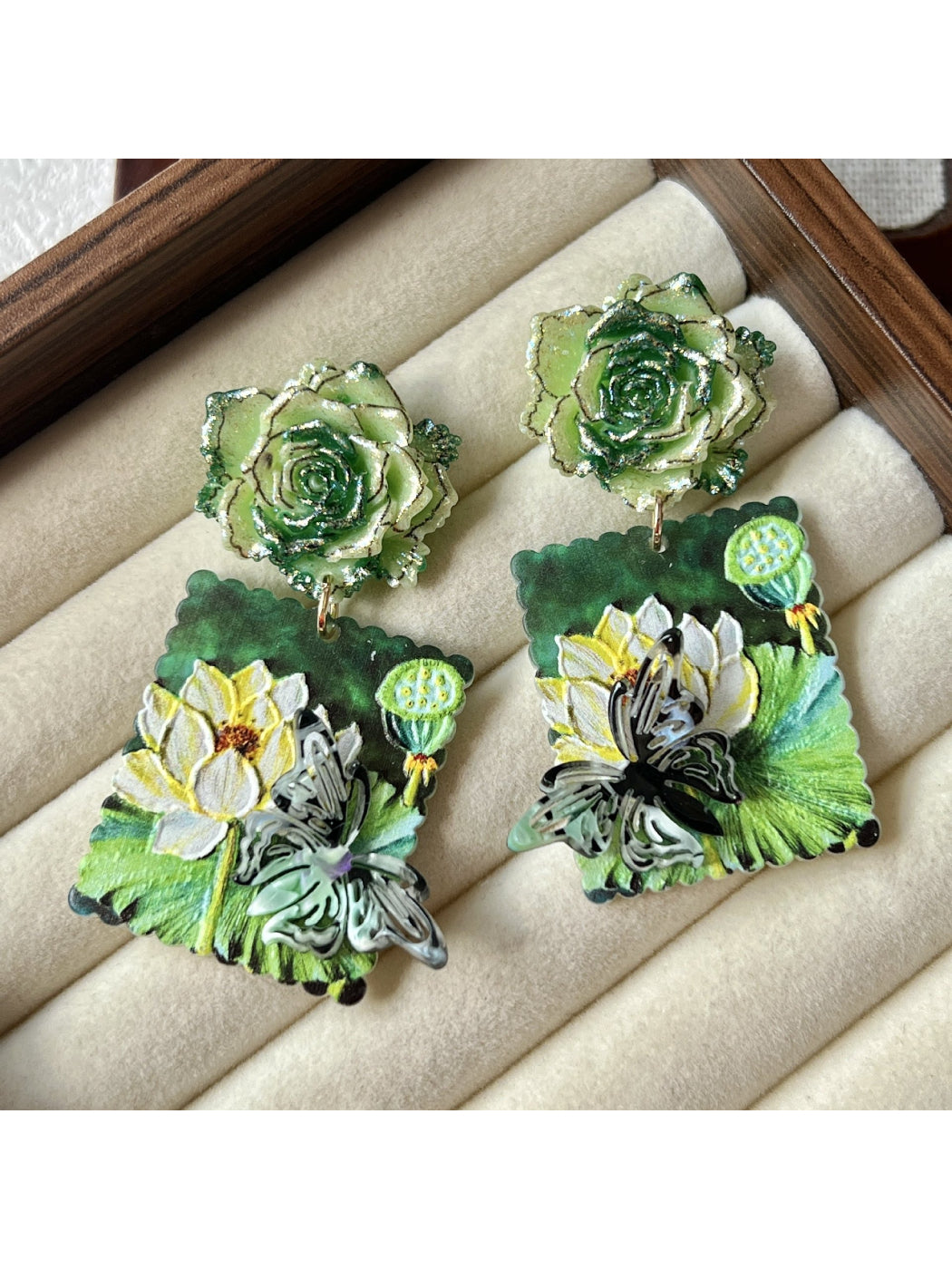 Earwish Lotus Garden earrings displayed on a white jewelry stand with soft lighting