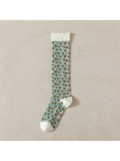 Rufia socks displayed on a wooden surface with soft light