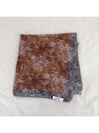 Scarvii scarf folded to highlight intricate floral border and soft fabric texture