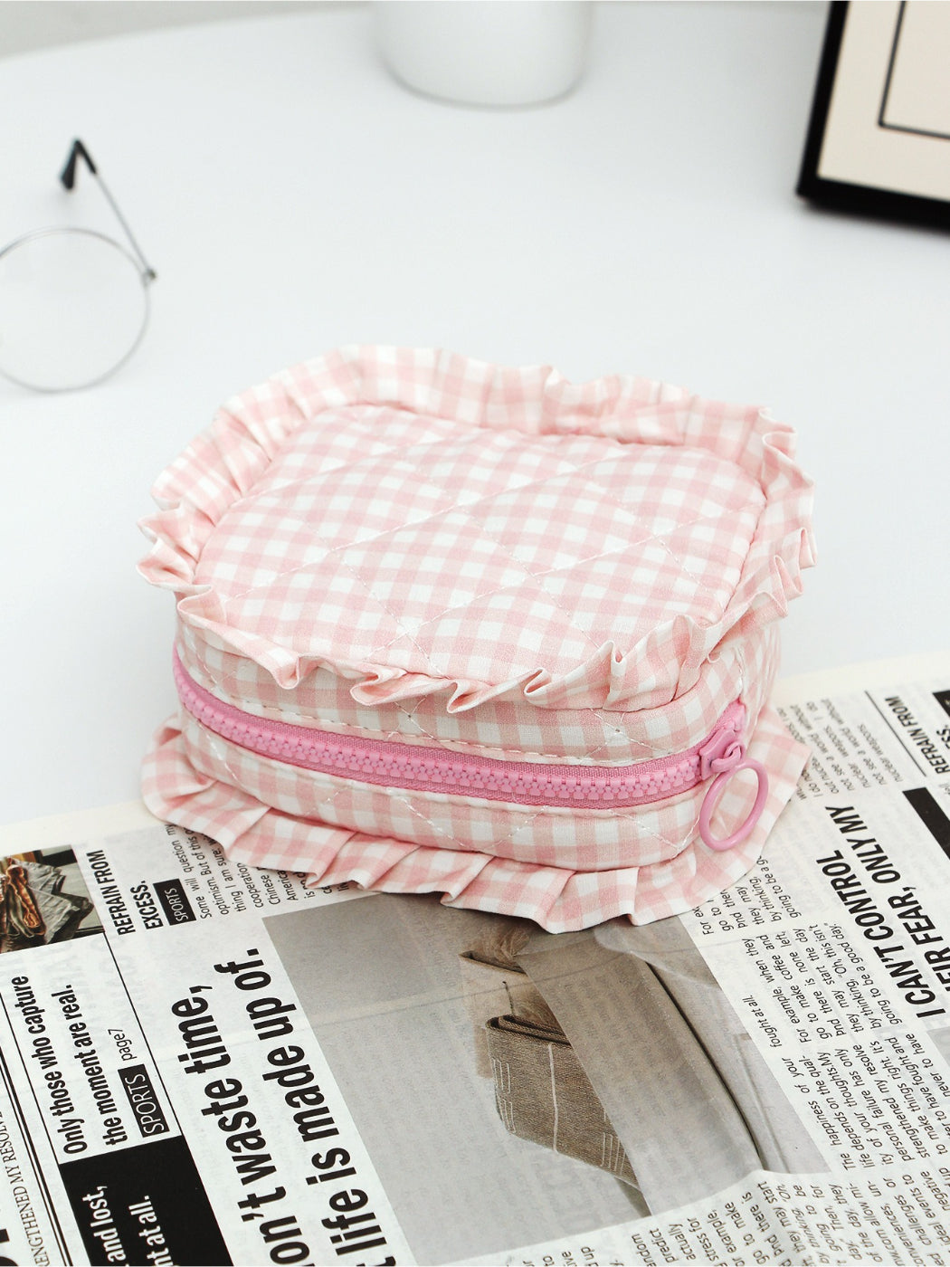 Three Cosbai checkered makeup pouches with ruffle trim arranged side by side