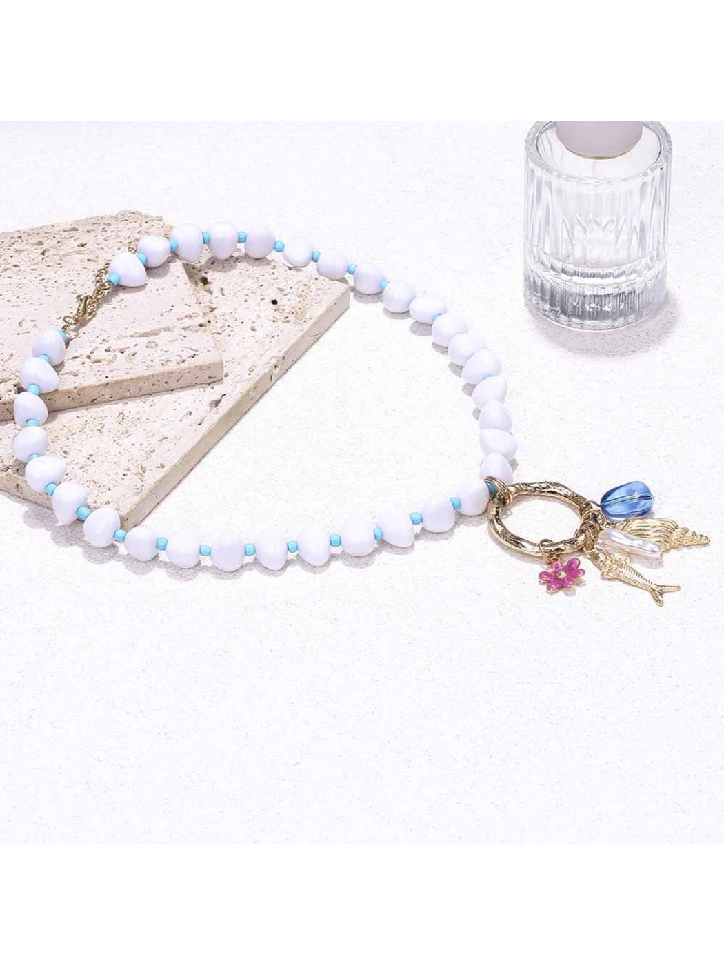 Neckit beaded necklace with ring charm shown coiled on a neutral background