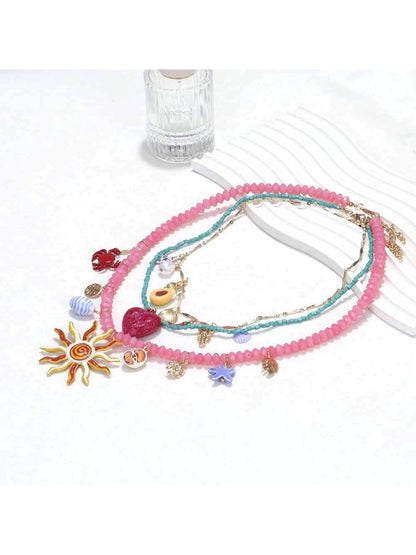 Neckit layered charm necklace displayed flat showing sun and heart charms