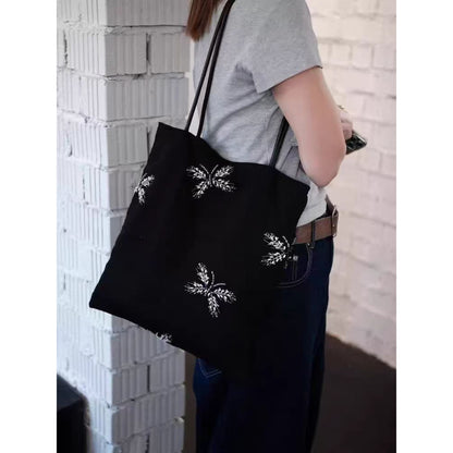 Top view of black beaded tote bag highlighting open interior and handles