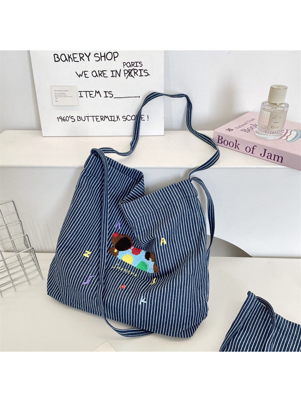 Close-up of animal embroidery detail on striped Cosbai tote bag