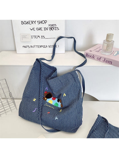 Close-up of animal embroidery detail on striped Cosbai tote bag